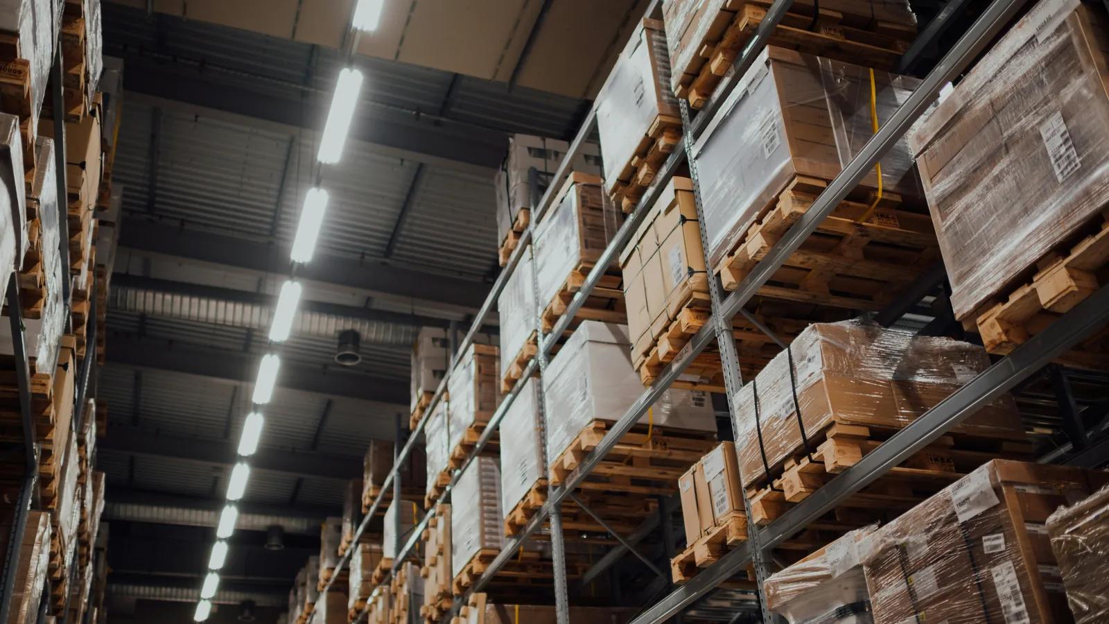 Palletised cases on warehouse racking, representing minimum order quantities for Italian food imports