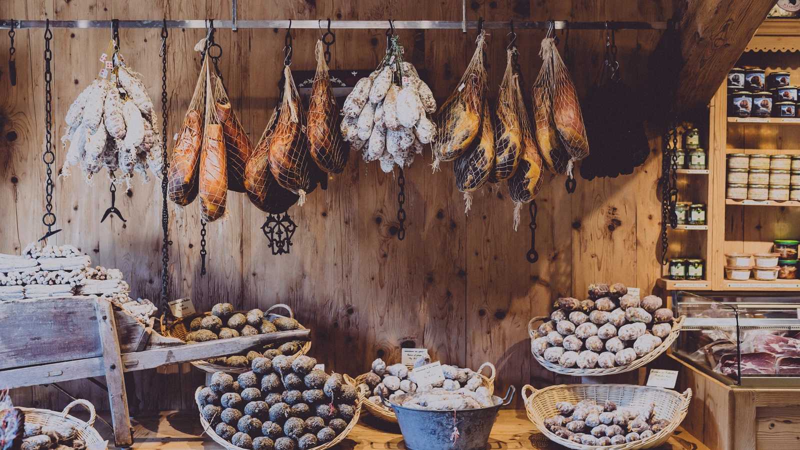 Hanging Italian salumi, prosciutto and salami in a traditional Italian salumeria display